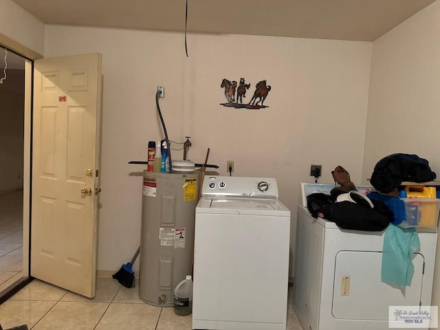 clothes washing area featuring washer and dryer, electric water heater, and light tile patterned floors