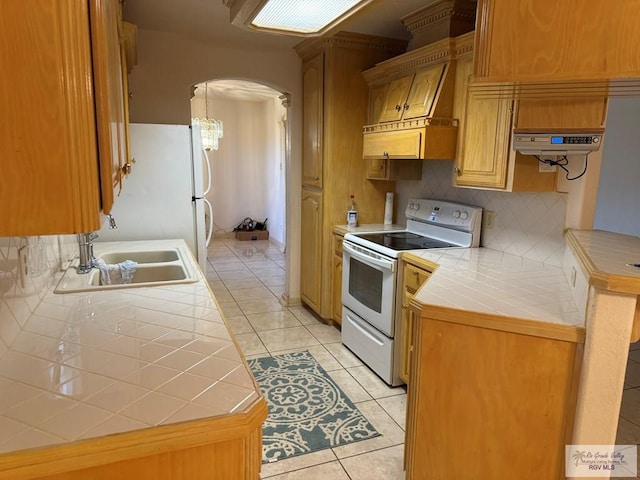 kitchen with tile countertops, white appliances, sink, decorative backsplash, and light tile patterned floors