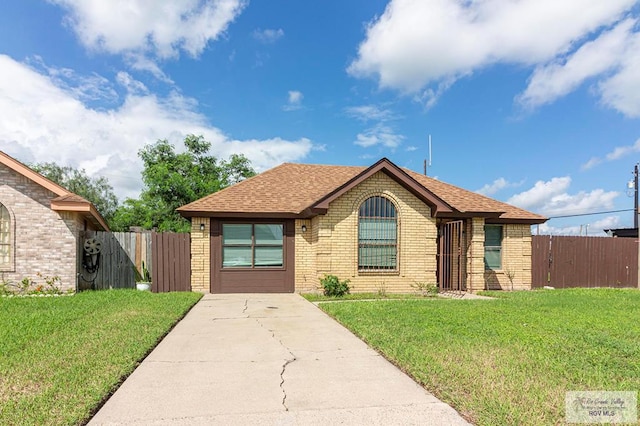 view of front of property featuring a front lawn, concrete driveway, and brick siding