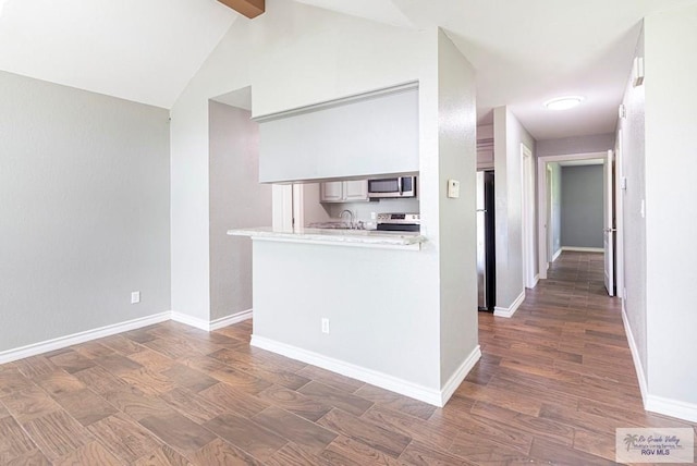 interior space featuring a sink, baseboards, dark wood-type flooring, and vaulted ceiling with beams
