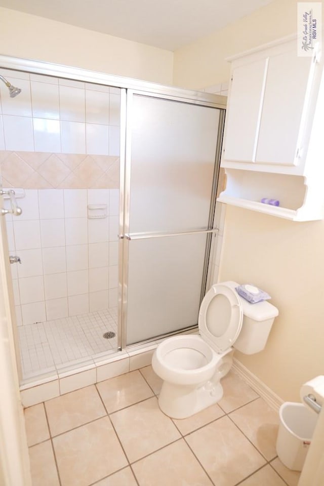 9165 Los Olmos Dr, Los Fresnos, TX 78566 - bathroom featuring toilet, a stall shower, and tile patterned floors