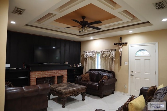 living room with a fireplace, a raised ceiling, and ceiling fan