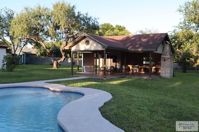 view of swimming pool with a lawn, a storage unit, and a patio