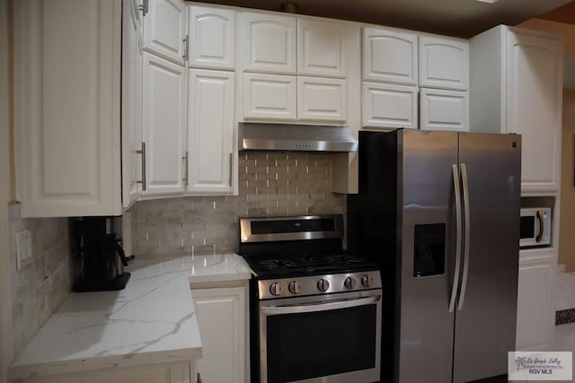 kitchen featuring white cabinets, stainless steel appliances, and tasteful backsplash