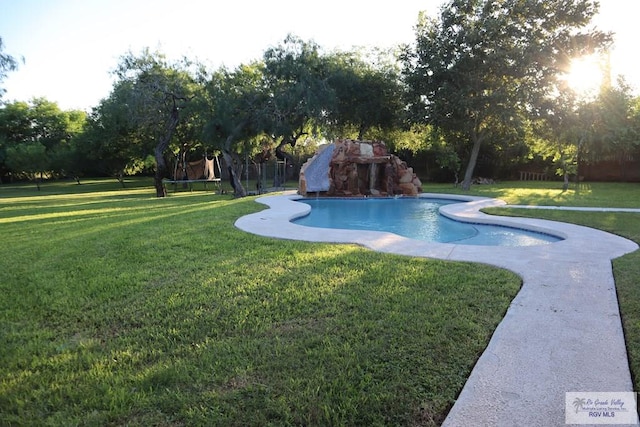 view of swimming pool featuring a lawn