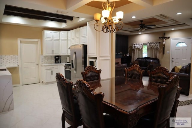 dining area with beamed ceiling, ceiling fan with notable chandelier, a tray ceiling, and coffered ceiling