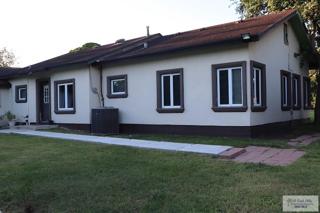 view of side of home featuring a lawn and cooling unit