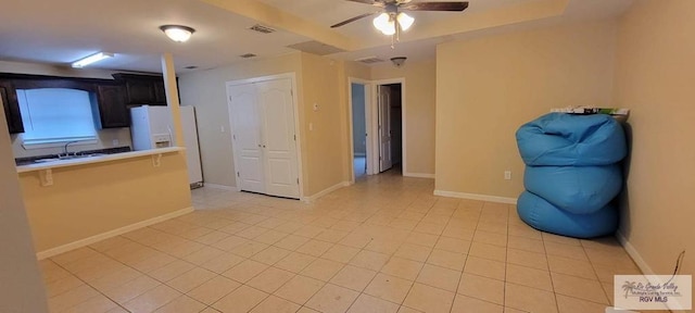 tiled spare room with ceiling fan and sink