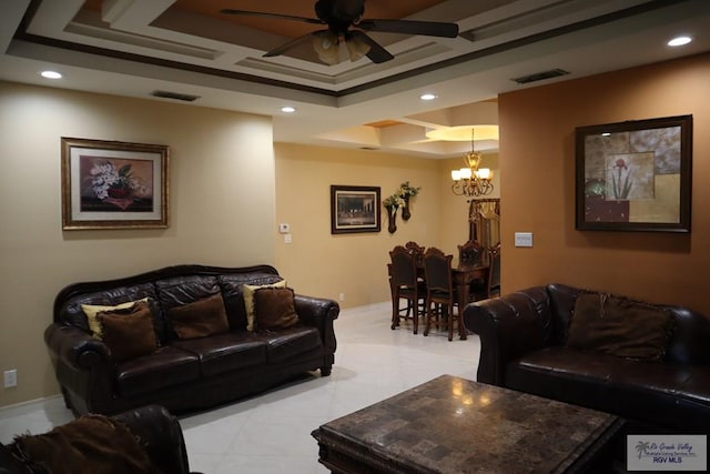 living room featuring ceiling fan with notable chandelier and a tray ceiling