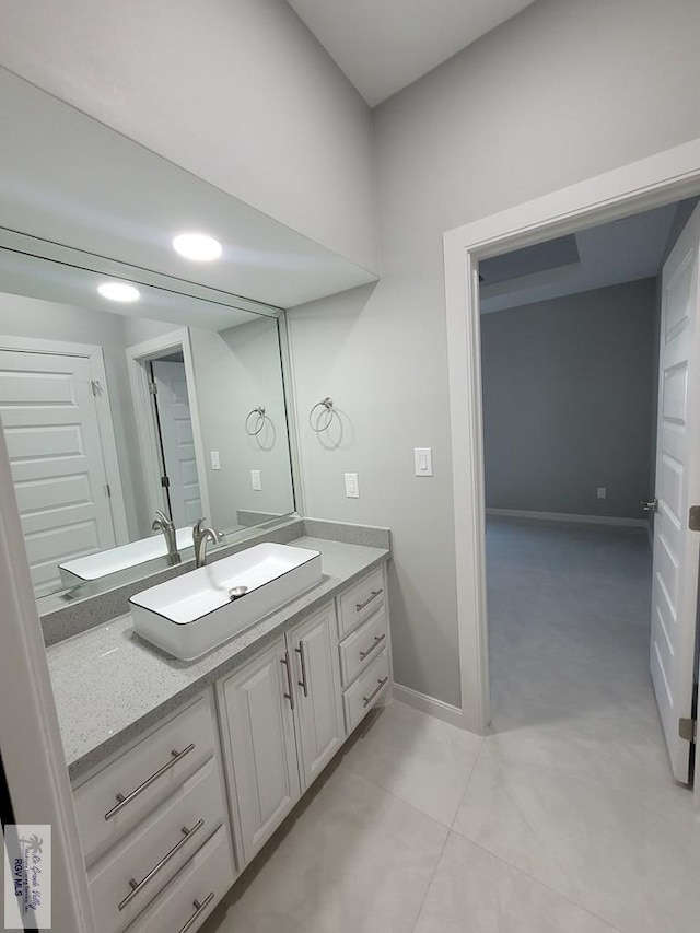 bathroom with vanity, baseboards, and tile patterned flooring
