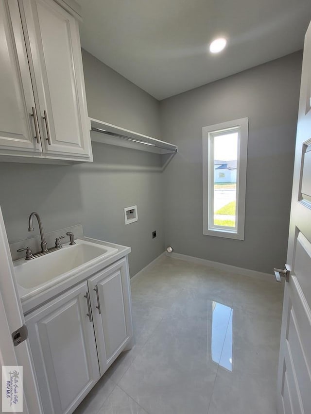 laundry area with baseboards, a sink, hookup for an electric dryer, cabinet space, and hookup for a washing machine
