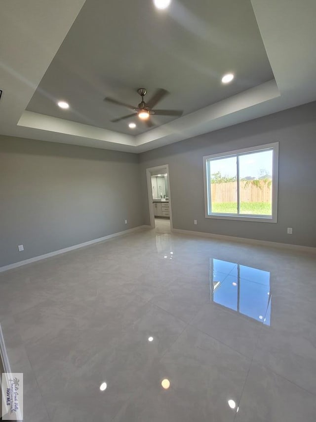 spare room featuring light tile patterned floors, baseboards, a raised ceiling, ceiling fan, and recessed lighting