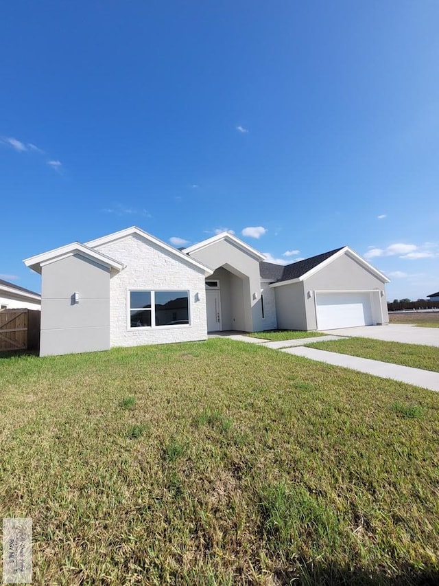 single story home featuring concrete driveway, stucco siding, an attached garage, a front yard, and fence