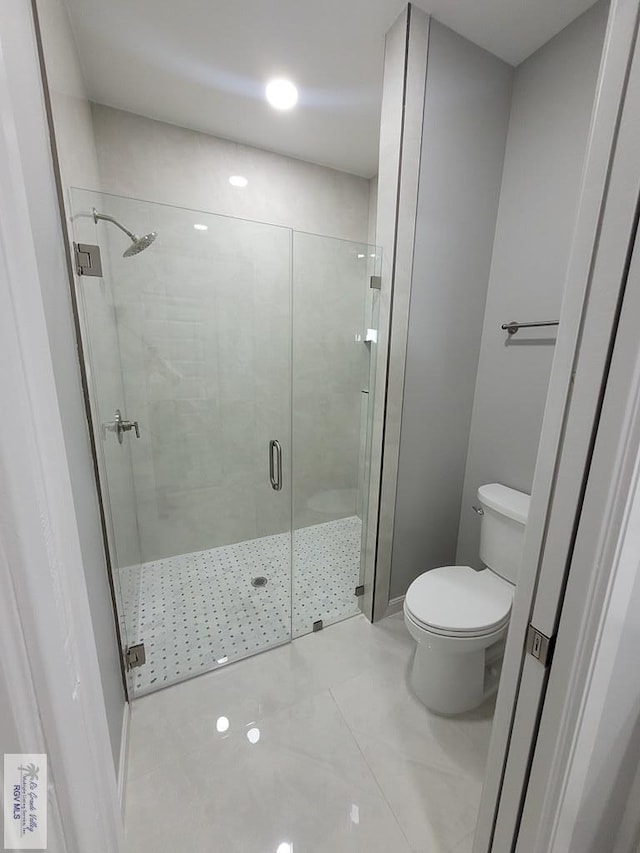 bathroom featuring toilet and a stall shower