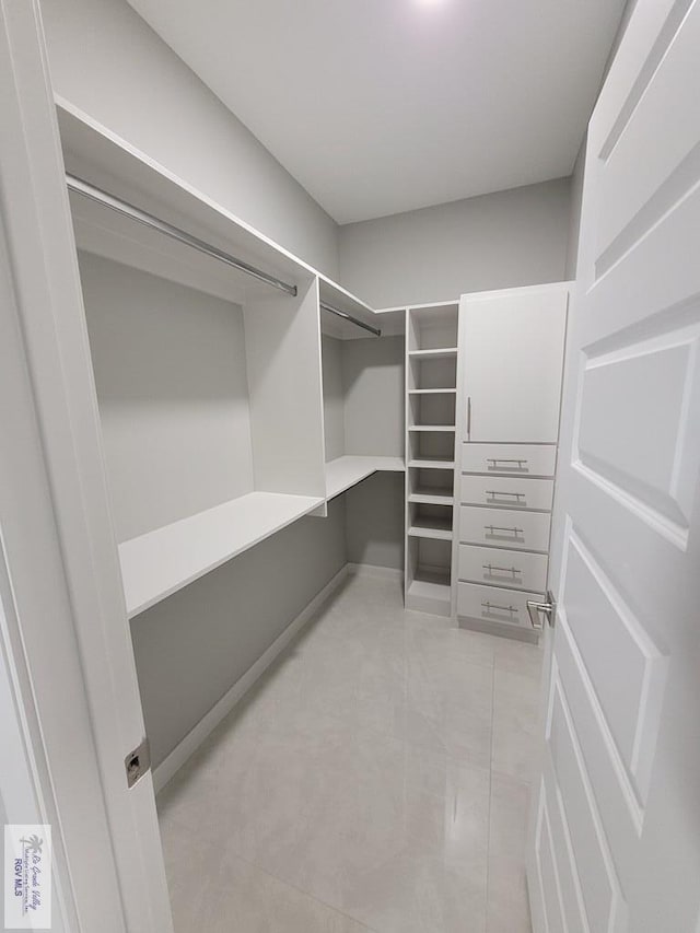 spacious closet featuring light tile patterned floors