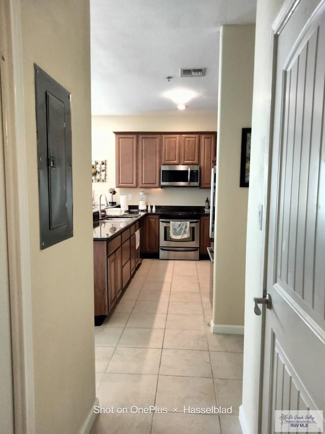 kitchen with electric panel, visible vents, appliances with stainless steel finishes, a sink, and light tile patterned floors
