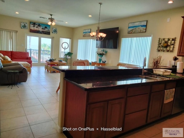 kitchen featuring pendant lighting, dark countertops, open floor plan, recessed lighting, and a sink