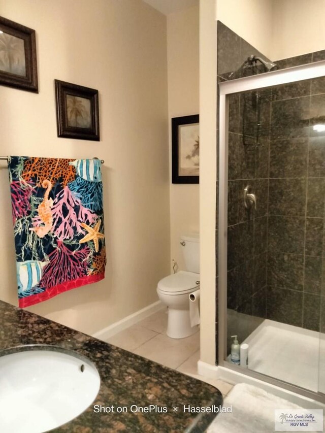 301 E Houston St Unit 1201, Port Isabel, TX 75052 - bathroom featuring a sink, tile patterned flooring, toilet, baseboards, and a shower stall