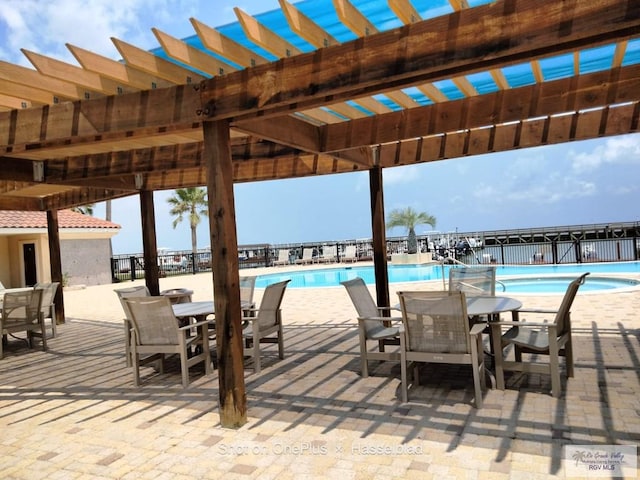 pool with fence, a pergola, and outdoor dining area