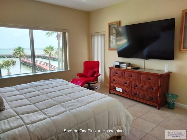 bedroom with light tile patterned floors and baseboards