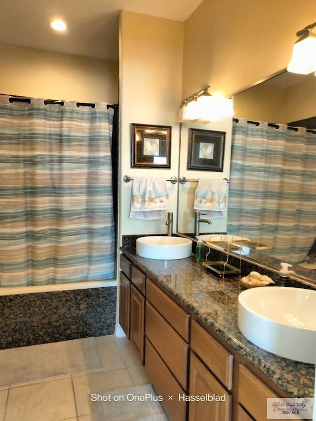 bathroom featuring a sink, tile patterned floors, shower / bathtub combination with curtain, and double vanity