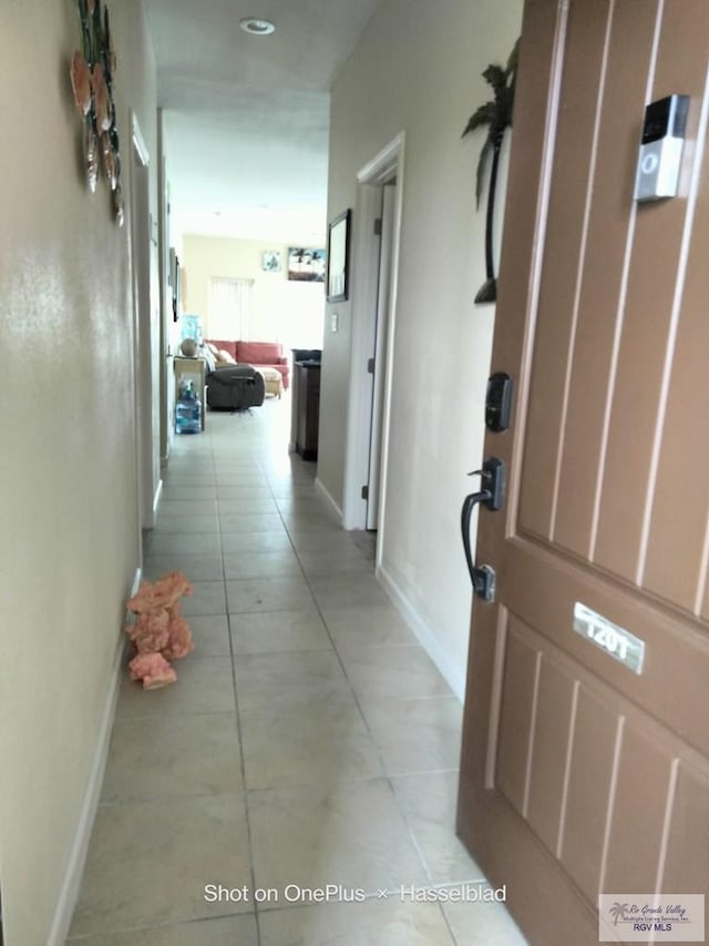 hall with light tile patterned floors and baseboards