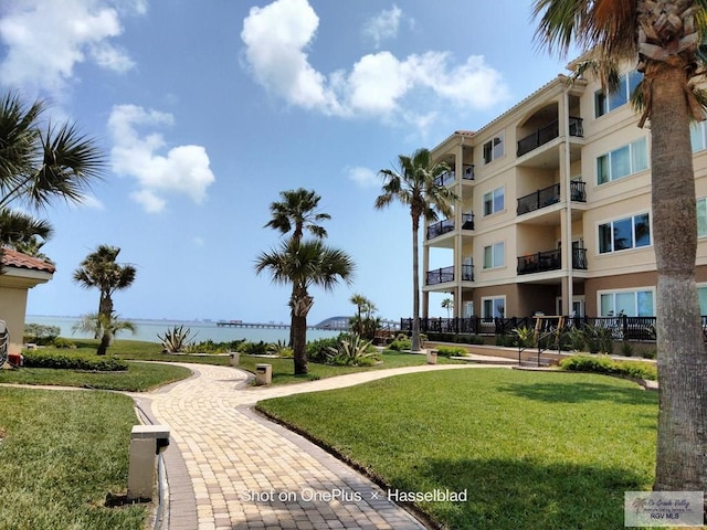 view of community with a yard and a water view