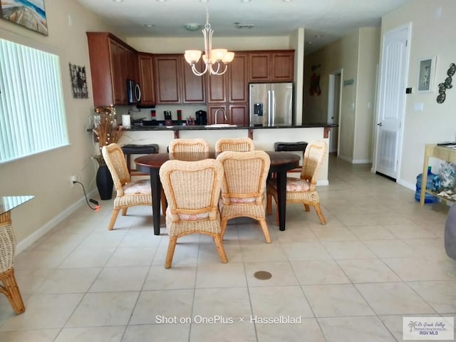dining space featuring baseboards, an inviting chandelier, and light tile patterned floors