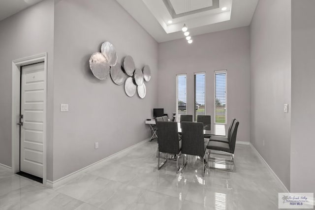 31689 E Jardin E, Los Fresnos, TX 78566 - dining area featuring a high ceiling, light marble finish flooring, a tray ceiling, and attic access