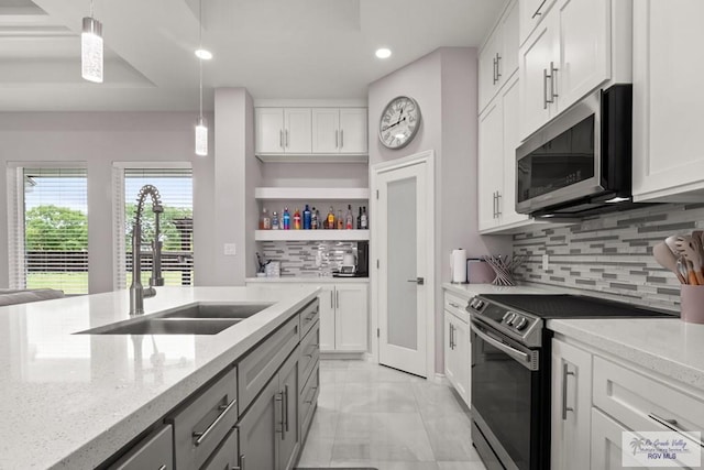 31689 E Jardin E, Los Fresnos, TX 78566 - kitchen featuring range with electric stovetop, stainless steel microwave, open shelves, recessed lighting, and tasteful backsplash
