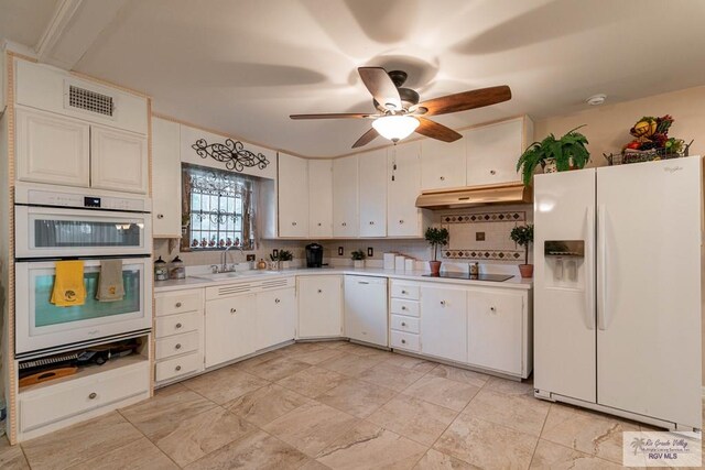 kitchen with white cabinets, white appliances, sink, and tasteful backsplash