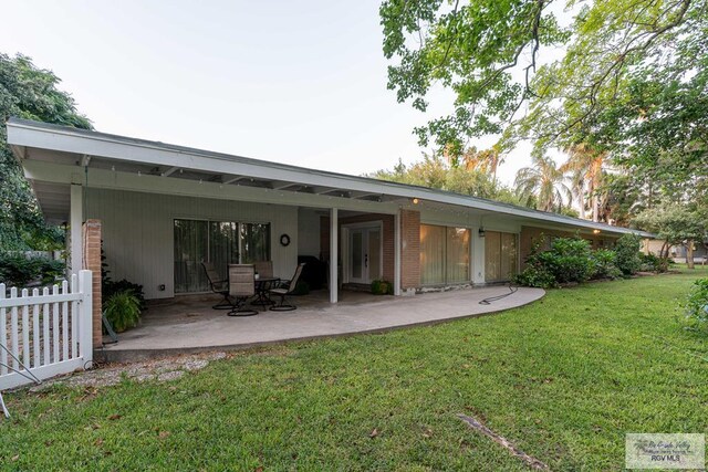 back of property featuring a yard and a patio