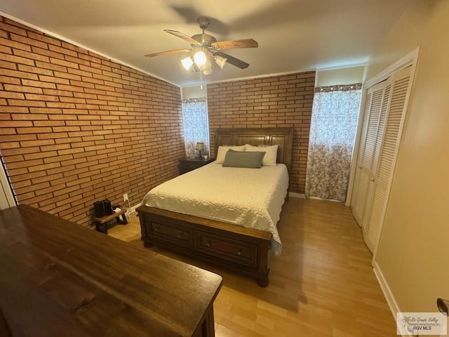 1901 Martha St, Harlingen, TX 78550 - bedroom with brick wall, light wood-type flooring, ceiling fan, and a closet