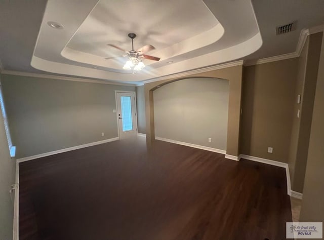 1714 Christian Cir, Harlingen, TX 78550 - unfurnished room with a raised ceiling, dark wood-style floors, a ceiling fan, baseboards, and ornamental molding