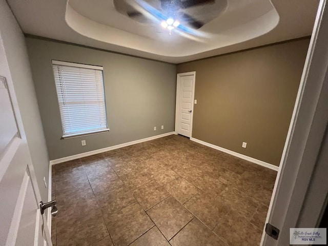 1714 Christian Cir, Harlingen, TX 78550 - spare room featuring a raised ceiling, a ceiling fan, tile patterned floors, and baseboards