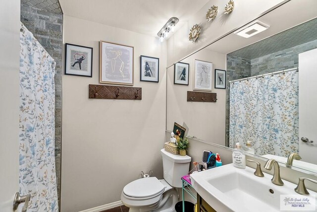 bathroom featuring a shower with curtain, vanity, and toilet