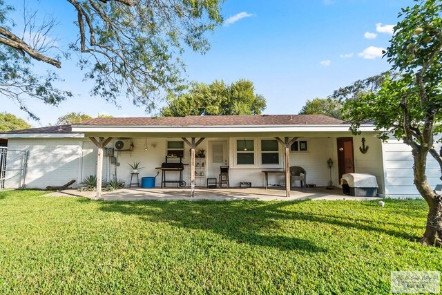 back of property with a lawn and a patio area