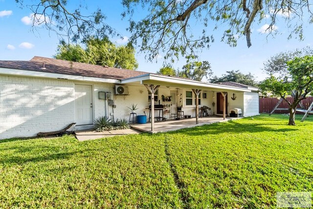 rear view of property with a lawn and a patio area