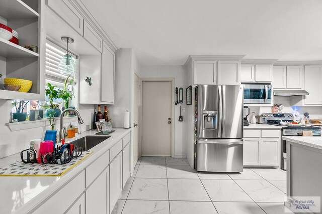 kitchen featuring appliances with stainless steel finishes, white cabinetry, pendant lighting, and sink