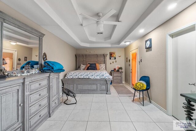 tiled bedroom featuring a tray ceiling and ceiling fan