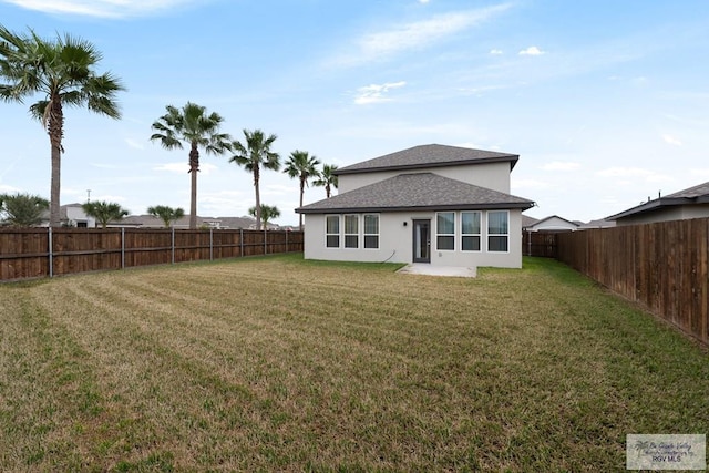 rear view of house featuring a lawn and a patio