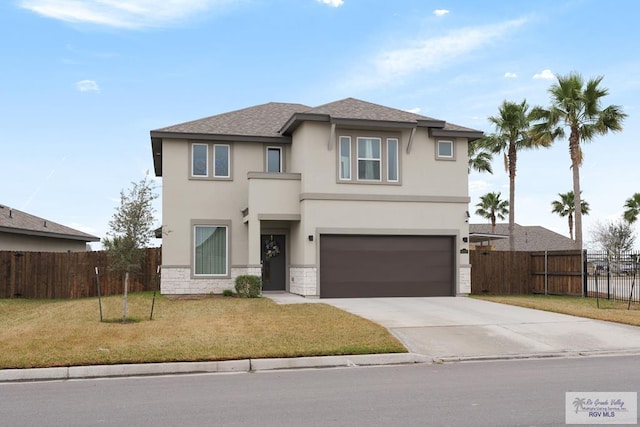 view of property featuring a garage and a front lawn