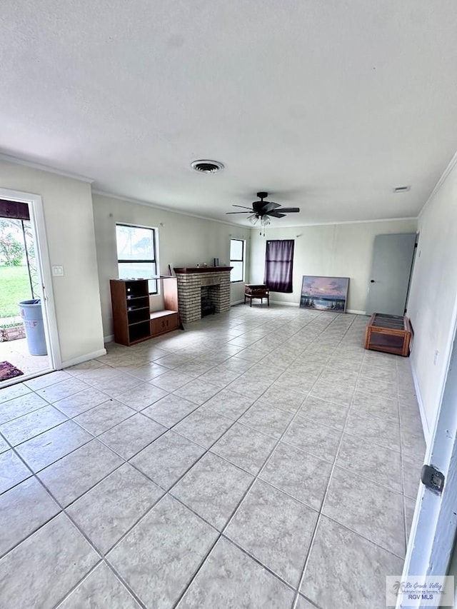 12776 State Highway 186, Raymondville, TX 78580 - living area with a brick fireplace, healthy amount of natural light, crown molding, light tile patterned floors, and baseboards