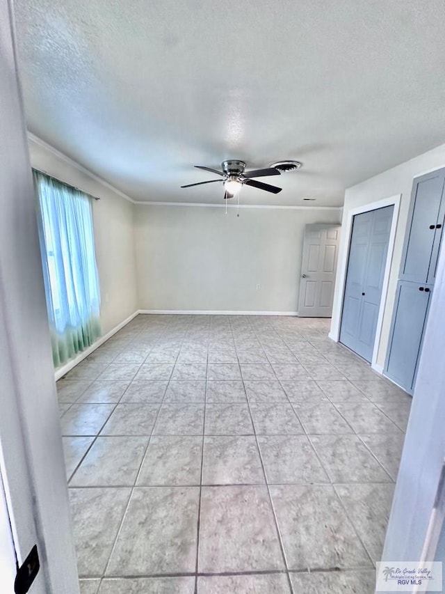 12776 State Highway 186, Raymondville, TX 78580 - empty room with ceiling fan, a textured ceiling, baseboards, light tile patterned flooring, and ornamental molding