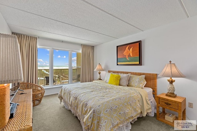 carpeted bedroom featuring a textured ceiling and wooden walls