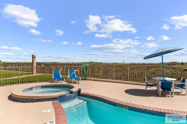 view of swimming pool featuring an in ground hot tub and a patio