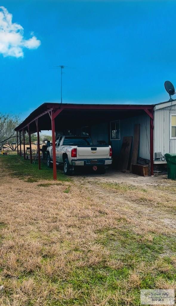 view of vehicle parking featuring a carport and a yard