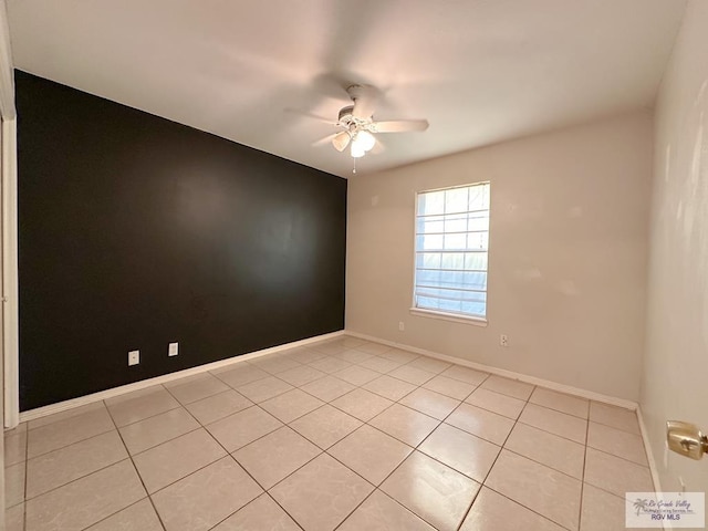 tiled spare room with ceiling fan