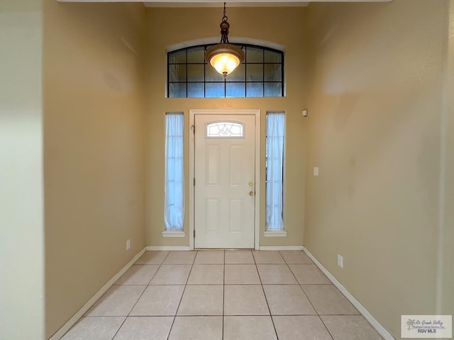 foyer with a towering ceiling and light tile patterned flooring