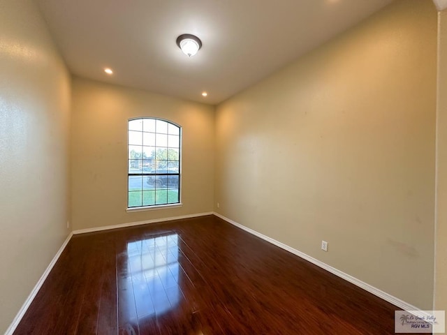 unfurnished room with dark hardwood / wood-style flooring